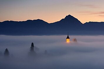 Небольшая деревушка Jamnik в Словении в утреннем тумане.