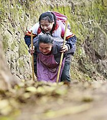 Китайская бабушка пять лет подряд носила больную внучку в школу на спине