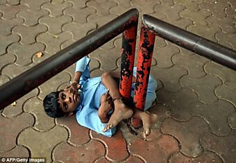 Индийская бабушка привязывает своего внука за ноги к автобусной остановке