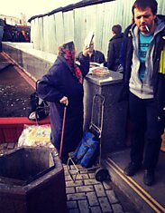 Бабушка стоит на выходе со станции метро Марксистская.