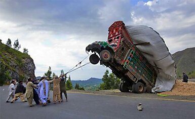Пакистанцы пытаются поставить на колеса грузовик