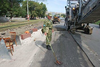 Солдат с миноискателем обследовал автомобильную дорогу